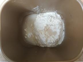 除黄油和盐外，面团材料按照先液体后粉类的顺序依次投入面包机桶，干酵母在面粉中间挖一个坑填入