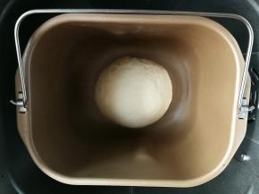 取出和面搅拌棒，将面团收圆，放在面包机桶中间，开启面包机发酵功能进行发酵