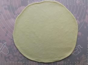 松弛后的面团用擀面杖擀成比9寸披萨盘略大一点的圆形片状