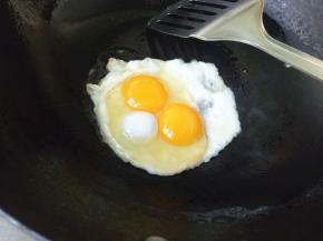 平底锅放少许油，温热时磕进鸡蛋。