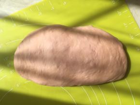 将面团取出，倒在揉面垫上，按压排气