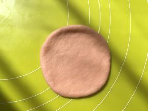 取一份松弛好的面团，擀成圆形，松弛好的面团有轻微回弹，回弹太大，是面团还没松弛好