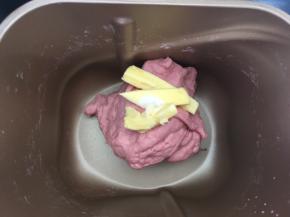 加入盐跟软化的黄油，继续启动揉面程序，将面团揉均匀