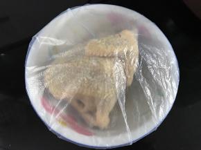 先用料酒把鸡身抹一遍，然后把混合好的沙姜盐均匀地抹在鸡身上，里面也上抹上；抹完后包上保鲜膜放冰箱冷藏一夜。