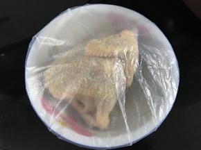先用料酒把鸡身抹一遍，然后把混合好的沙姜盐均匀地抹在鸡身上，里面也上抹上；抹完后包上保鲜膜放冰箱冷藏一夜。