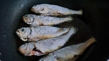 热锅凉油，依次加入黄花鱼，中小火煎制定型