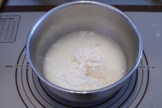 将饺子粉倒入盆内，再缓慢倒入开水