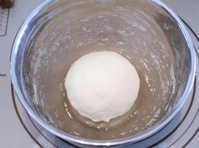 等面粉稍凉之后，用手将面团揉均匀，盖上保鲜膜松弛30分钟