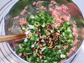 开始做饺子馅：将猪肉剁成肉泥，加入生抽、盐、胡椒粉、鸡精和芝麻油，然后用筷子一个方向搅拌出筋
