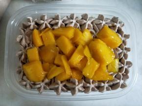 表面用裱花嘴挤一圈花纹，内部放上一层芒果。