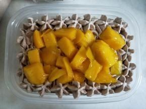 表面用裱花嘴挤一圈花纹，内部放上一层芒果。