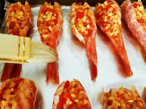 烤盘垫锡纸，预热烤箱，220度十分钟左右，把爆香的蒜泥辣椒碎填入虾背里面，用刷子在虾子外面刷一层植物油