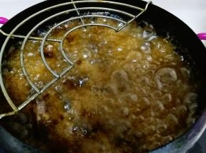 油锅烧至八分热，把虾头倒进油锅里炸熟