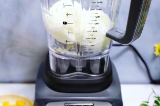 将酸奶冰块用勺子敲碎后，放入搅拌杯里。

