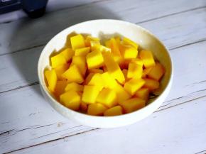 首先将芒果切成三片，打十字花刀，用刀子沿果皮将果肉划下。

