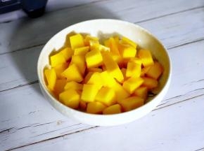 首先将芒果切成三片，打十字花刀，用刀子沿果皮将果肉划下。

