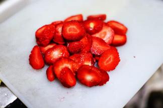 将草莓洗净去蒂，切成小块。