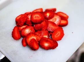将草莓洗净去蒂，切成小块。