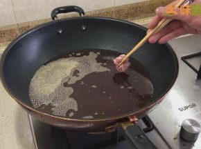 锅里放入食用油（需要没过排骨），等油温烧至7成热左右（开始有烟的时候），将排骨一块一块放入锅中炸制，切忌将所有排骨一起倒进锅内，避免排骨粘连，同时还可以保证每块排骨受热更加均匀。排骨水分炸干，表面金黄色即可捞出沥油。