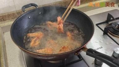 然后再放入虾，将水分炸干，炸制虾表面发硬即可捞出沥油