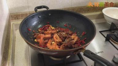 锅内留适量油，不能太多，以免影响干锅的口感。放入姜蒜片炒香，再加入3勺左右的郫县豆瓣酱，炒干豆瓣酱的水分散发出香味，加入干青花椒、干红花椒、干辣椒，炒出麻味和辣味后放入炸好的排骨和虾，翻炒均匀。（郫县豆瓣酱一定要在主料前放入，且要炒干炒香，不仅可以让菜的味道更香，还可以帮助食材上色。）