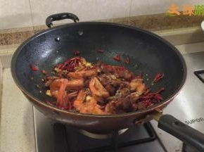 锅内留适量油，不能太多，以免影响干锅的口感。放入姜蒜片炒香，再加入3勺左右的郫县豆瓣酱，炒干豆瓣酱的水分散发出香味，加入干青花椒、干红花椒、干辣椒，炒出麻味和辣味后放入炸好的排骨和虾，翻炒均匀。（郫县豆瓣酱一定要在主料前放入，且要炒干炒香，不仅可以让菜的味道更香，还可以帮助食材上色。）