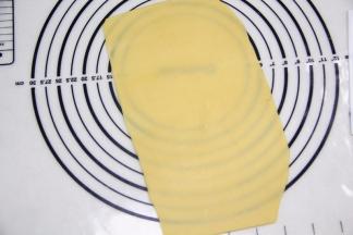 将面团压扁，擀至薄厚长短均匀