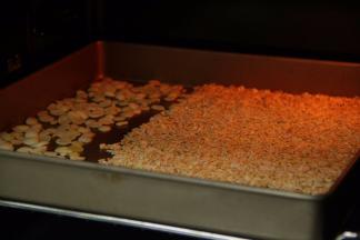 燕麦与杏仁片放入烤盘中，150度上下火烤至5分钟，烤至金黄变脆。