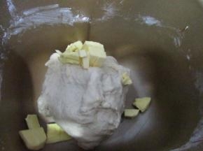 和面10分钟，面团能拉出很厚的膜，放入软化的黄油继续和面
