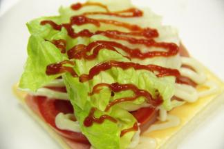 放上一片生菜，挤上番茄酱。