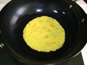 开火，在锅里倒入少许食用油，把鸡蛋液倒入锅内煎至两面金黄色。