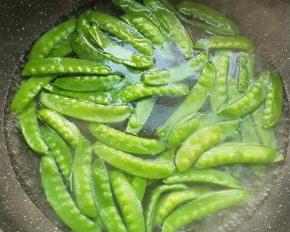 锅中水烧开，加少许盐少许食用油，倒入荷兰豆焯烫一会，捞出放凉水中浸泡，炒前捞出沥干。
