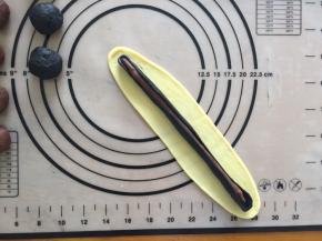 再将原味面团擀成长条形，抱住竹炭和可可面团