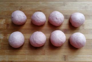 发酵好的面团取出来挤压排气，然后分成均匀的8份小面团滚圆，盖保鲜膜静置15分钟左右