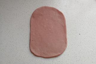 取一份静置好的小面团，用擀面杖擀成长方形的小面片