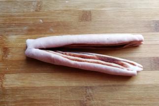 卷好后用刀从中间对半切开，顶端留一小部分不要切断