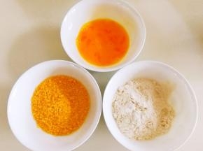 鸡蛋打散，面粉和面包糠倒在碗里