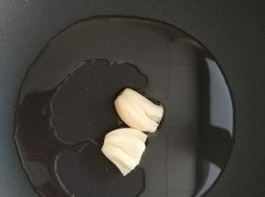 炒锅中加入食用油，放入大蒜，小火炒出香味。