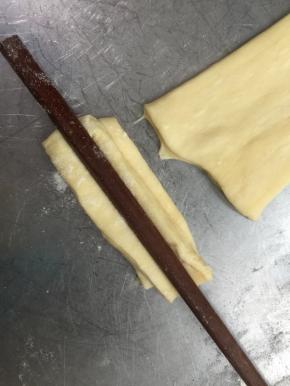 两片落在一起，用筷子在中间压一下。（下锅的图忘记拍了，下次补上吧）手捏住两端，稍微拉一拉，拉的长度要看你锅的大小，放到锅里浮起后，要注意翻动油条，使上色均匀，炸至金黄即可控油取出