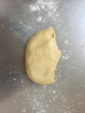 取出面团分割成两部分，面案上撒少许手粉