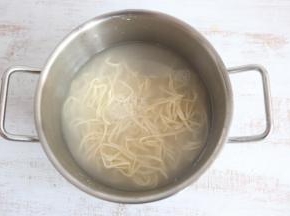 炒菜的同时，另起一锅开水煮面。面条煮至8成熟时，捞出过凉水。