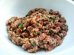 顺着一个方向搅拌上劲，最后加少许小葱，2勺芝麻油搅拌均匀，静止15分钟，让肉跟香菇的味道充分融合在一起，