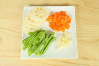 2.胡萝卜去皮，切片后用模具摁出图案；莲藕削皮后切片；荷兰豆去两边的蒂头，清洗干净；大蒜剥壳，拍碎。