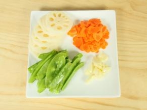 2.胡萝卜去皮，切片后用模具摁出图案；莲藕削皮后切片；荷兰豆去两边的蒂头，清洗干净；大蒜剥壳，拍碎。