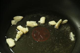 8.锅里放入适量的食用油，小火加热，加入蒜，煸炒出香味。