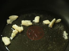 8.锅里放入适量的食用油，小火加热，加入蒜，煸炒出香味。