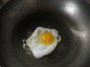 另起锅，锅里加入食用油，油热后敲入鸡蛋（我这里鸡蛋白煎熟，蛋黄还处于可流动状态，喜欢全熟鸡蛋的朋友可以慢火将鸡蛋煎熟），加入少量的盐调味；