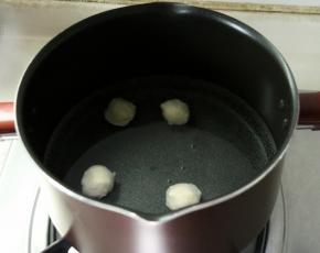 锅里加水，倒入适量的食用油，加入洗干净后的鱼丸开始煮；