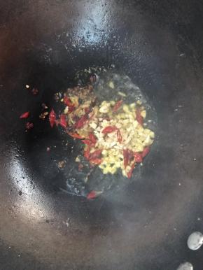 锅中留底油，加入姜、蒜末，干辣椒和花椒爆香