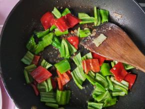 锅内的底油，放入青椒，红椒，翻炒。